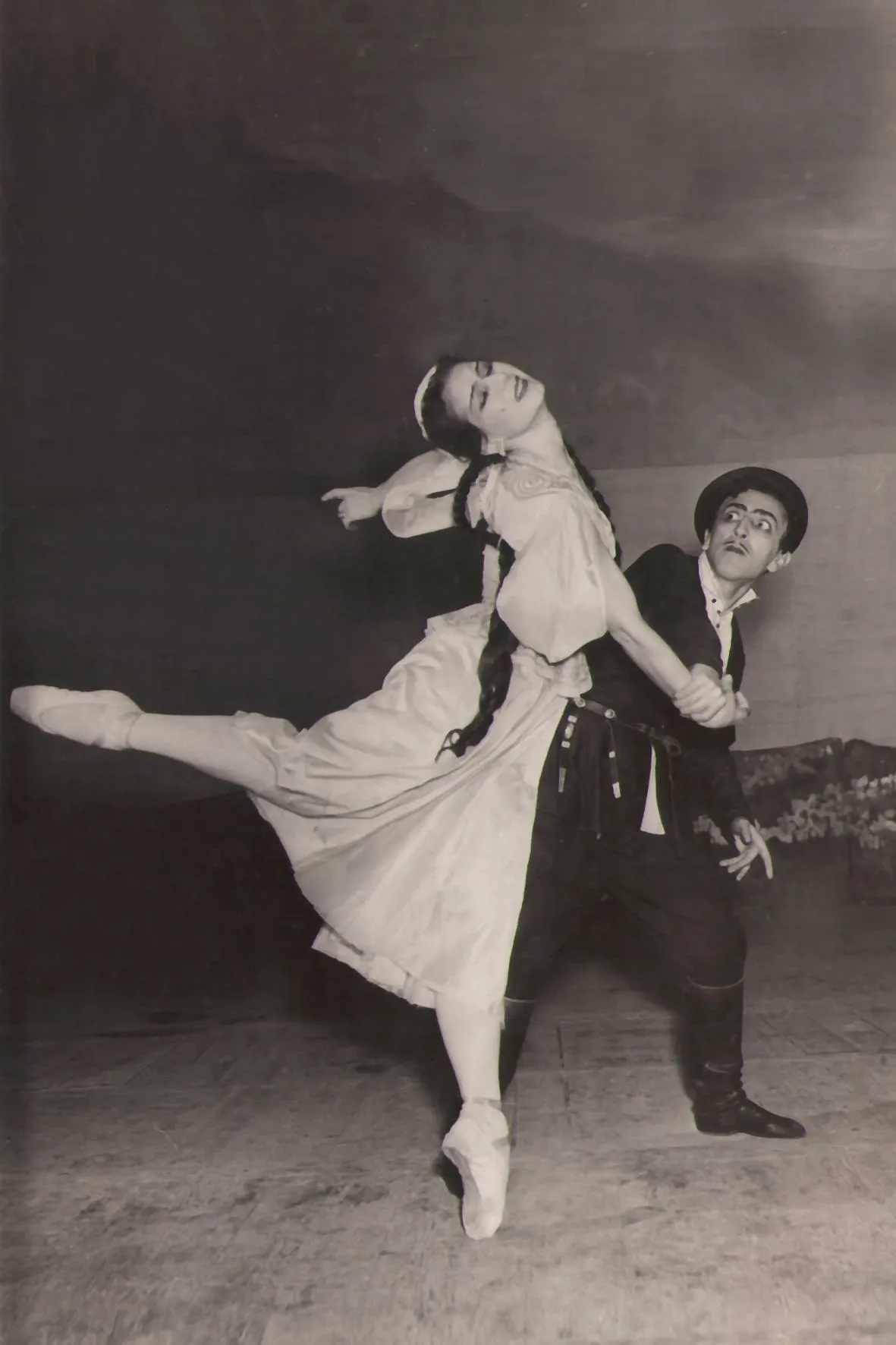 Pas de deux dramatique en noir et blanc, la danseuse cambrée dans les bras de son partenaire.