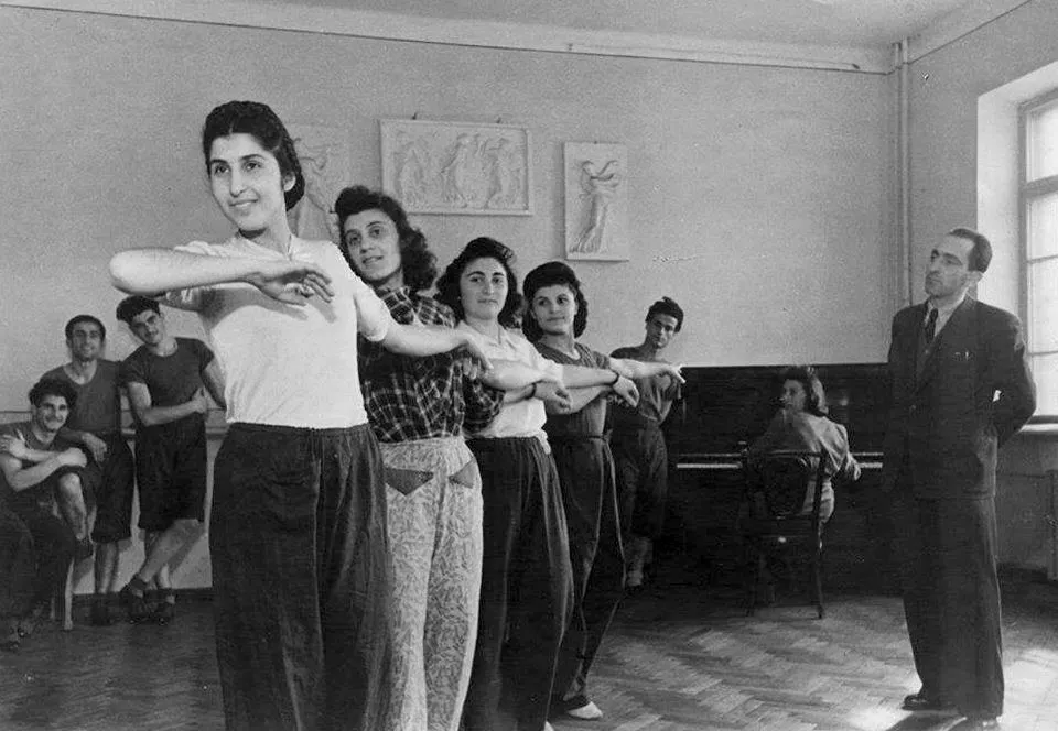 Une classe d'une autre époque : les danseurs en ligne, le professeur à leurs côtés.