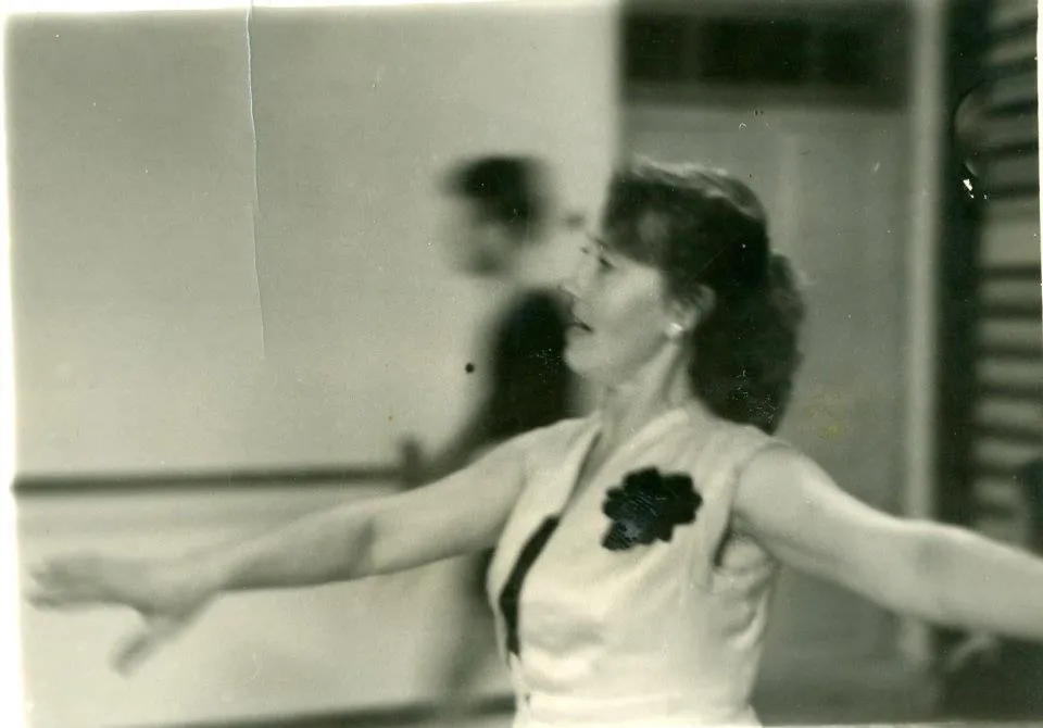 Une danseuse en mouvement, une rose au corsage, en studio.