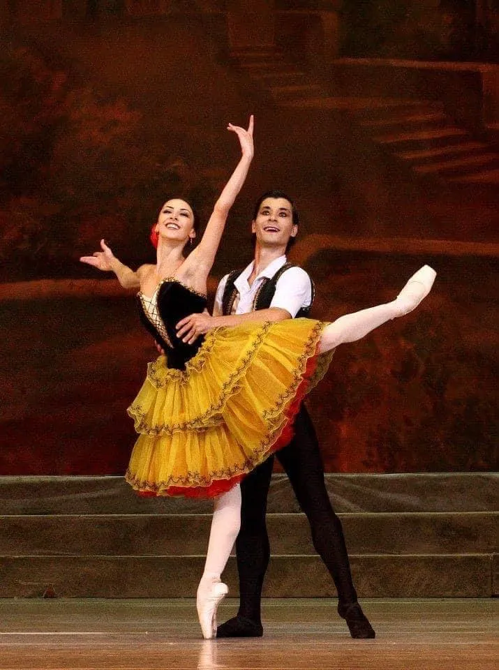 Pas de deux sur scène, tutu jaune et costume noir et or, tirage couleur d'époque.