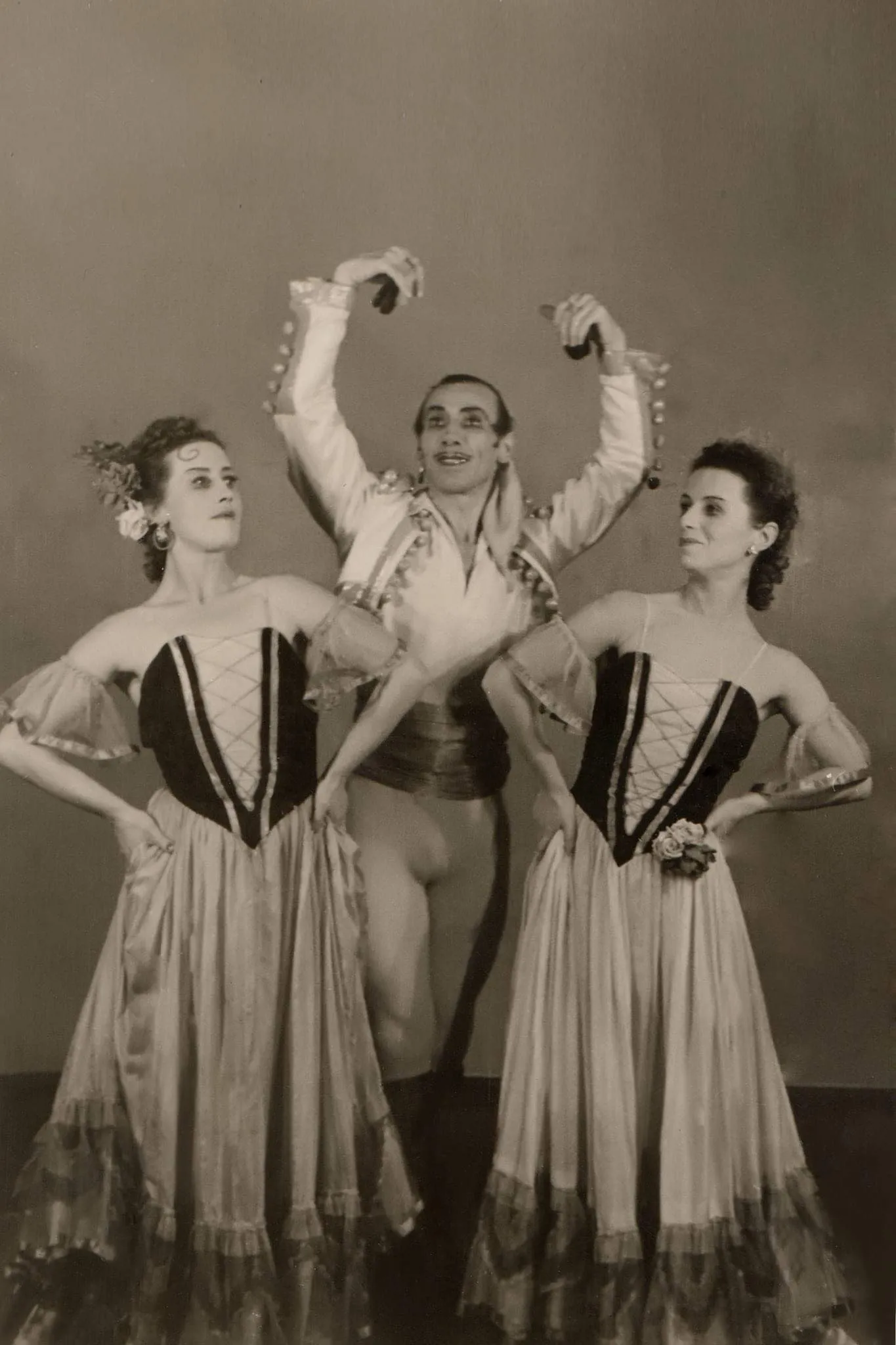 Tirage sépia : trois danseurs posent en costume de scène.