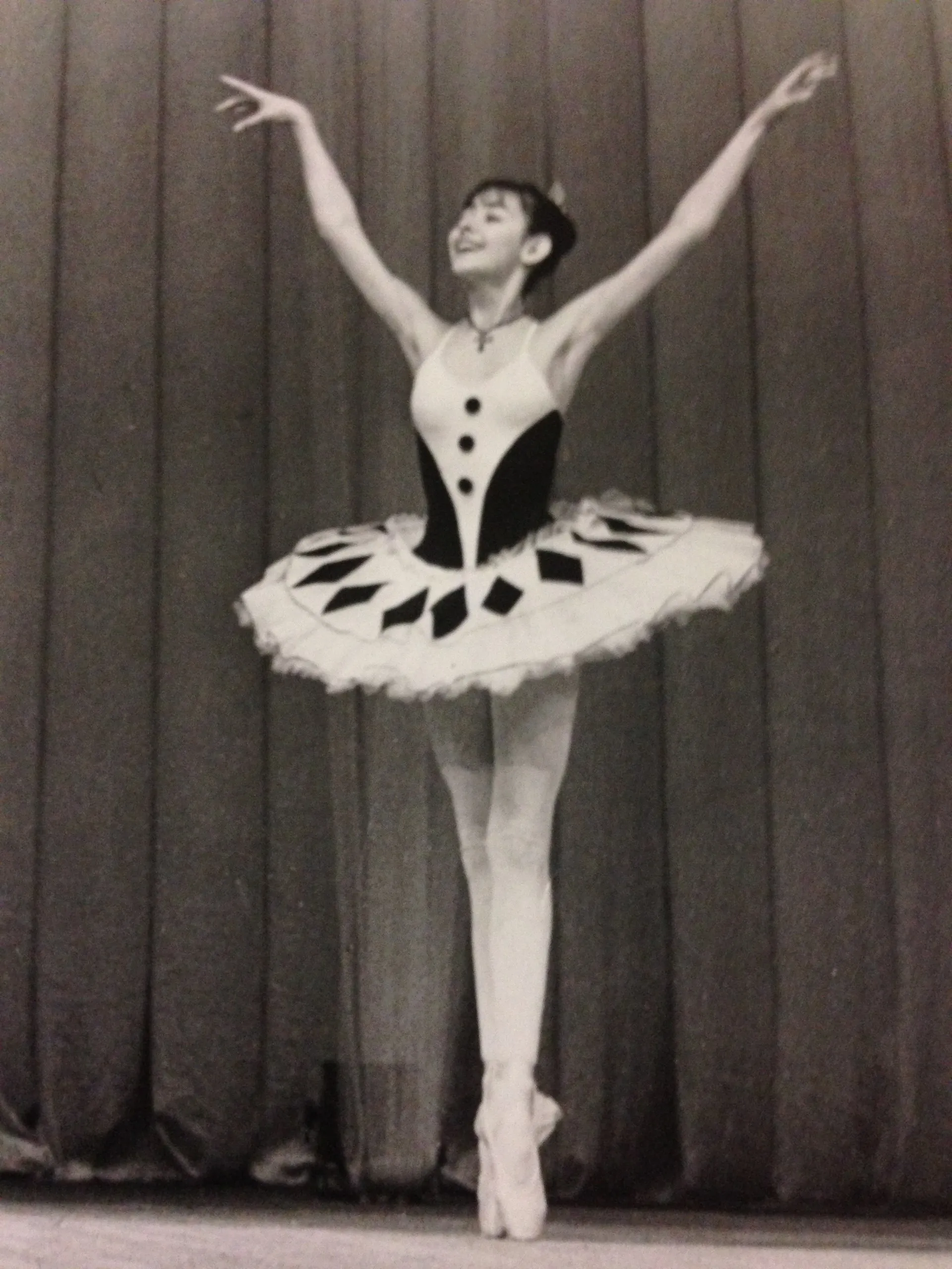 Jeune ballerine sur scène en tutu, photographie en noir et blanc.