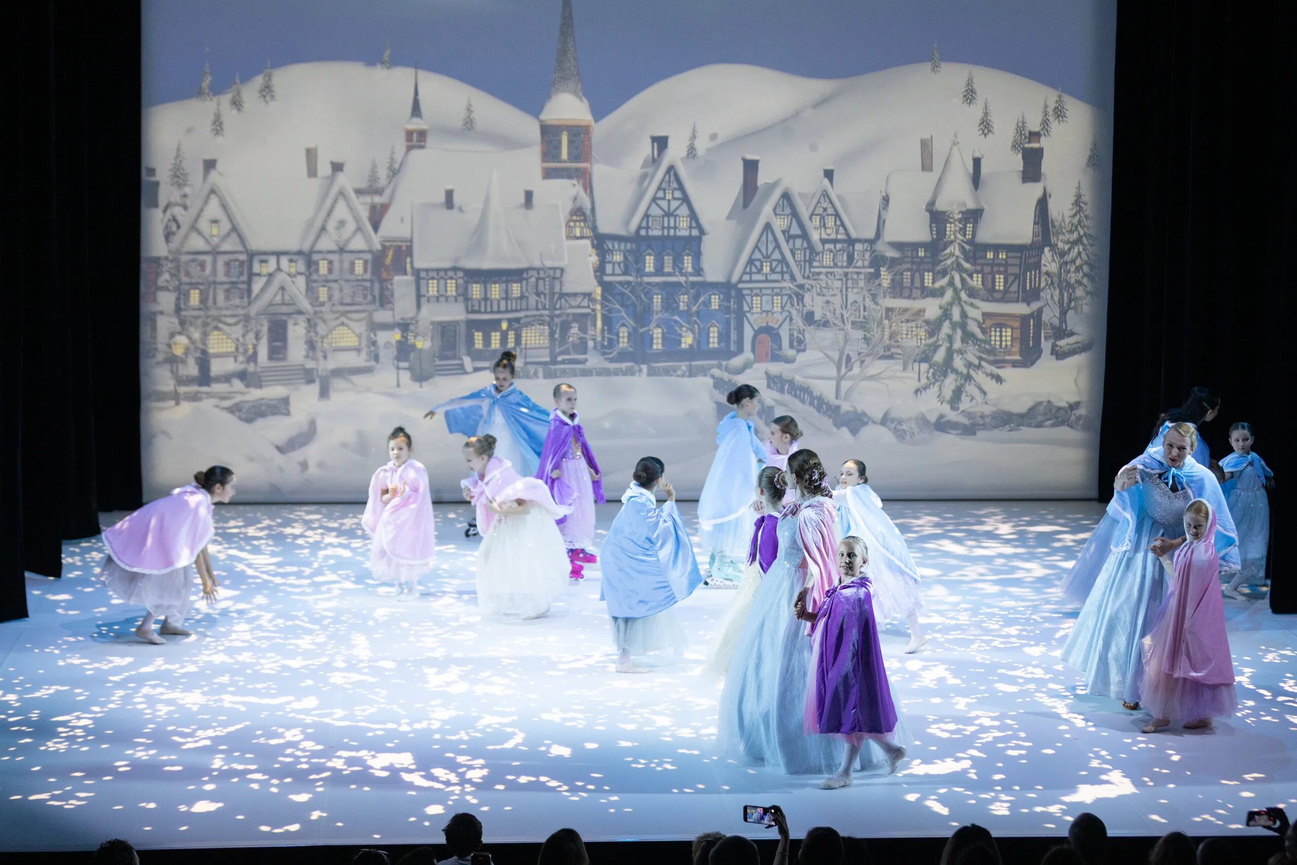 The village scene under the snow, the whole group in cloaks.
