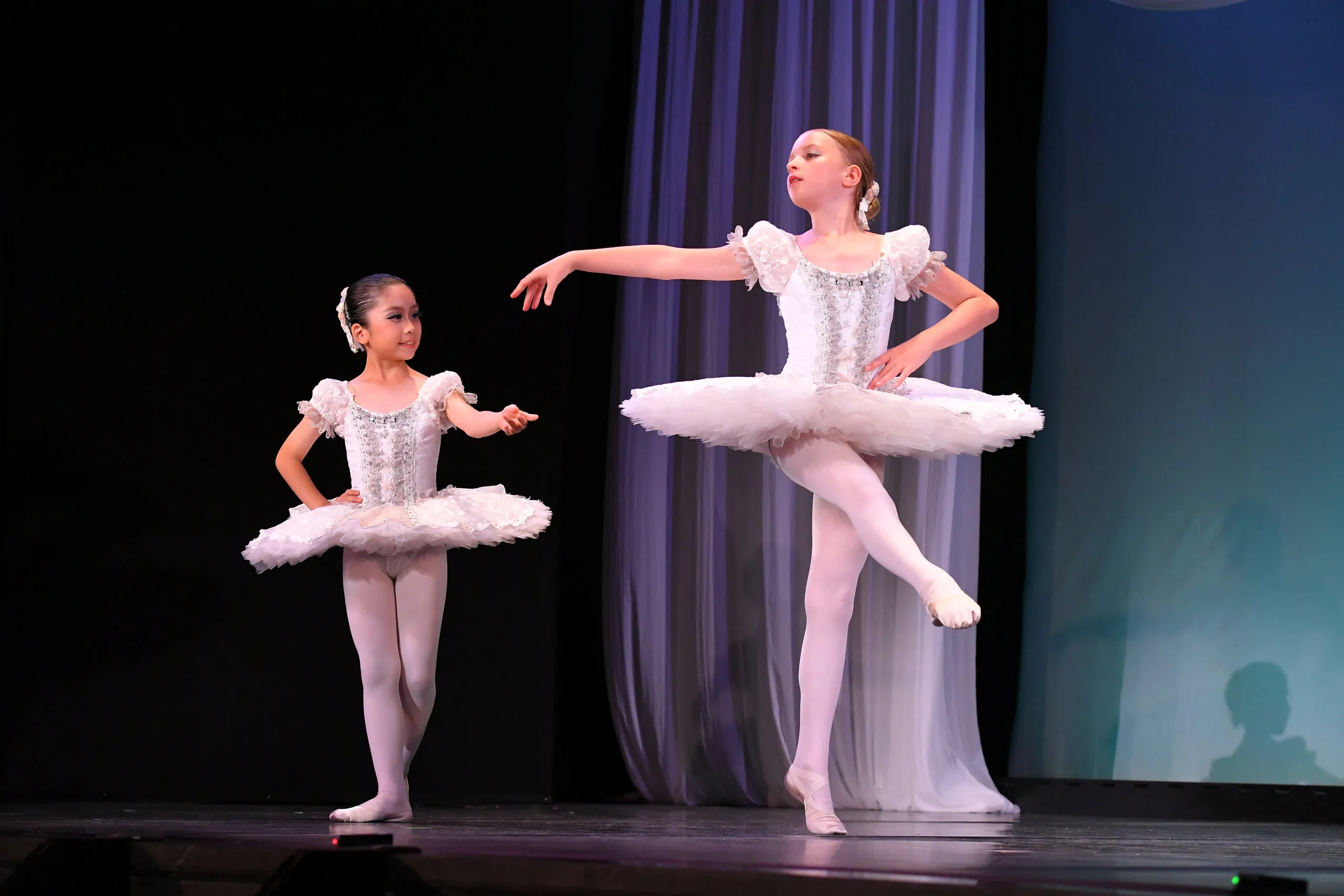 Deux danseuses en blanc, la plus jeune regardant la plus grande.