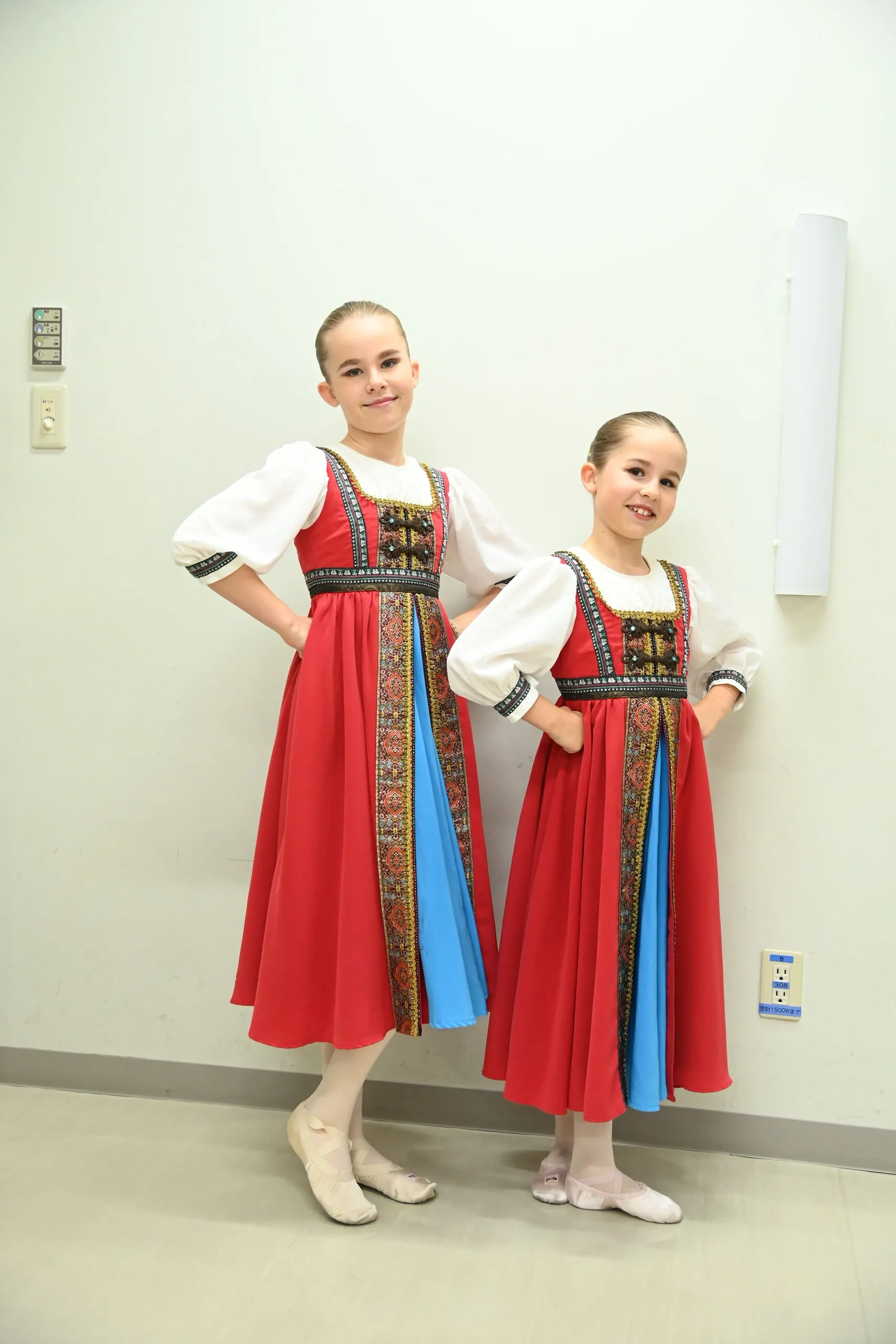 Deux élèves en costumes de caractère, prêtes dans le couloir des loges.
