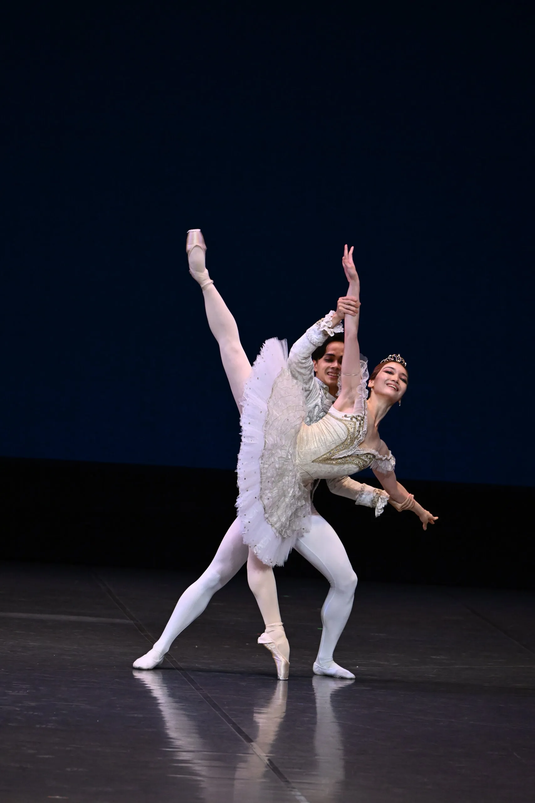 Pas de deux en tutu blanc, les deux figures entières sur fond bleu nuit.