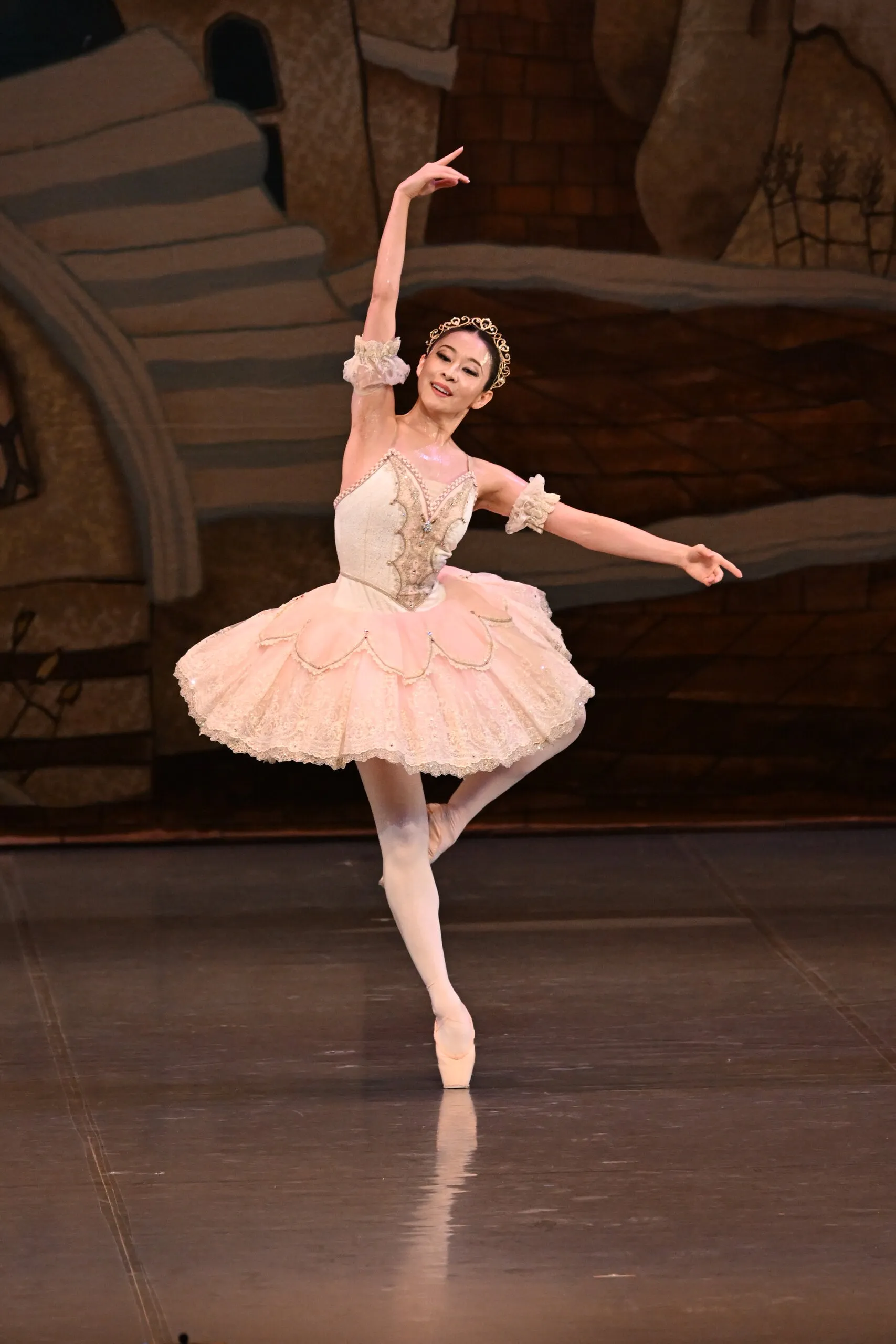 Une danseuse en tutu pêche dans sa variation, figure entière.