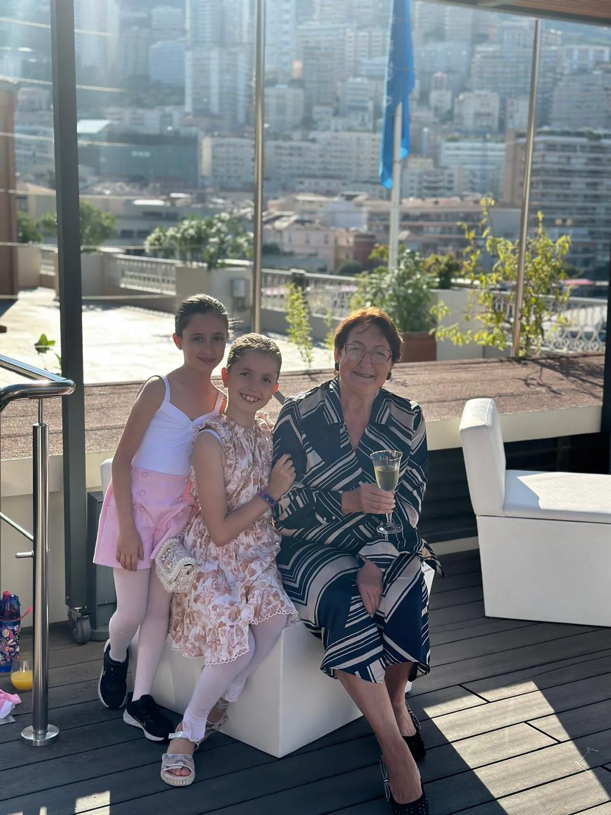 Deux élèves et une invitée sur la terrasse, les toits de Monaco derrière elles.