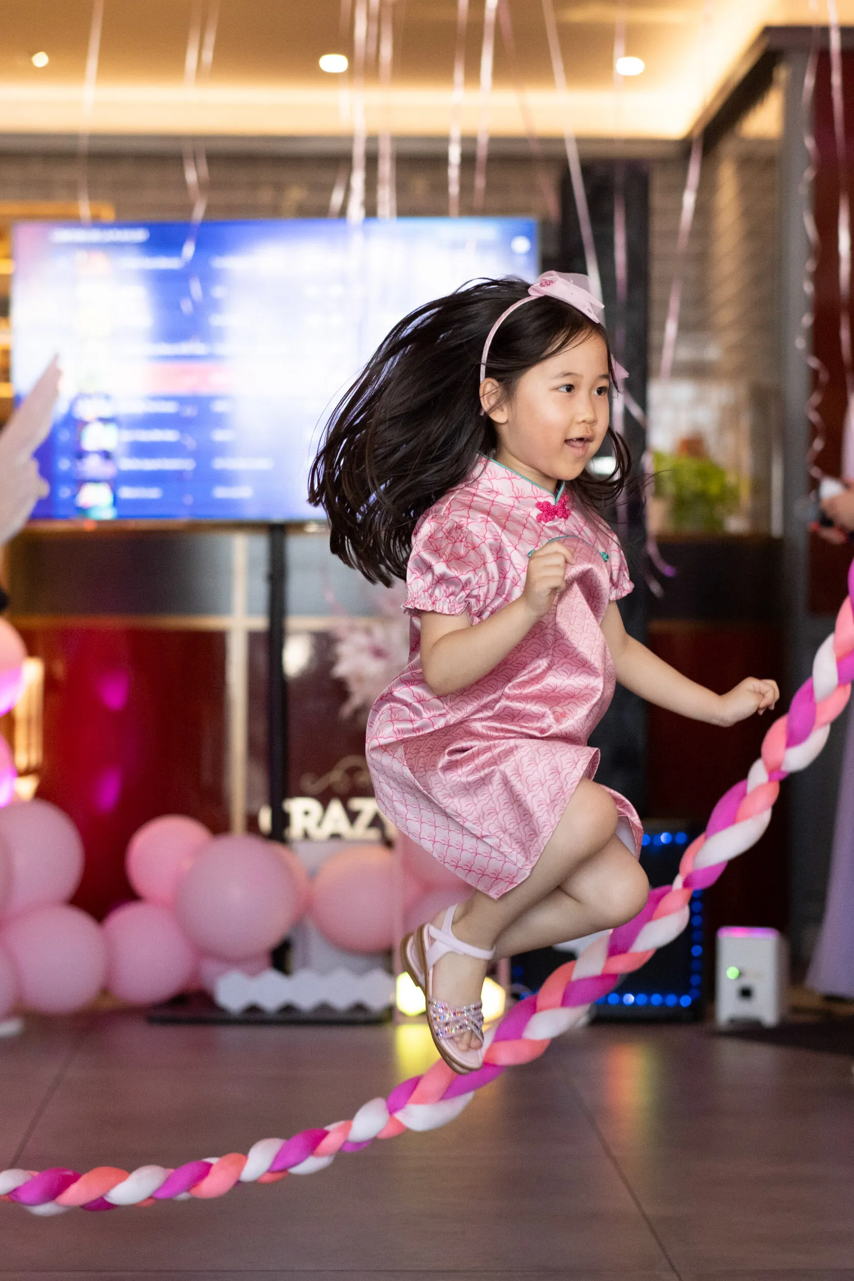 A child jumps over the braided rope, caught in mid air.