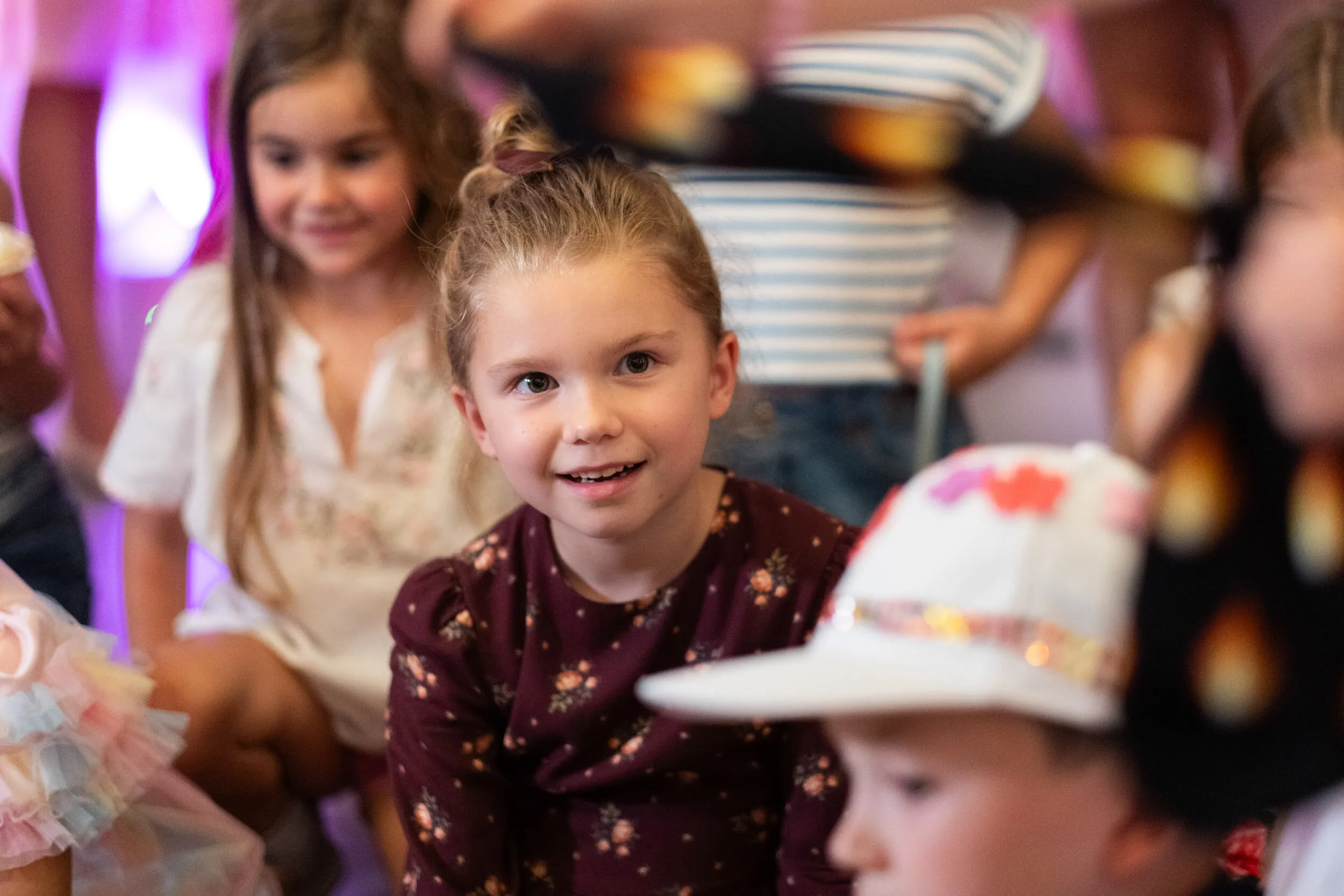 A child smiles in wonder in the middle of the audience.