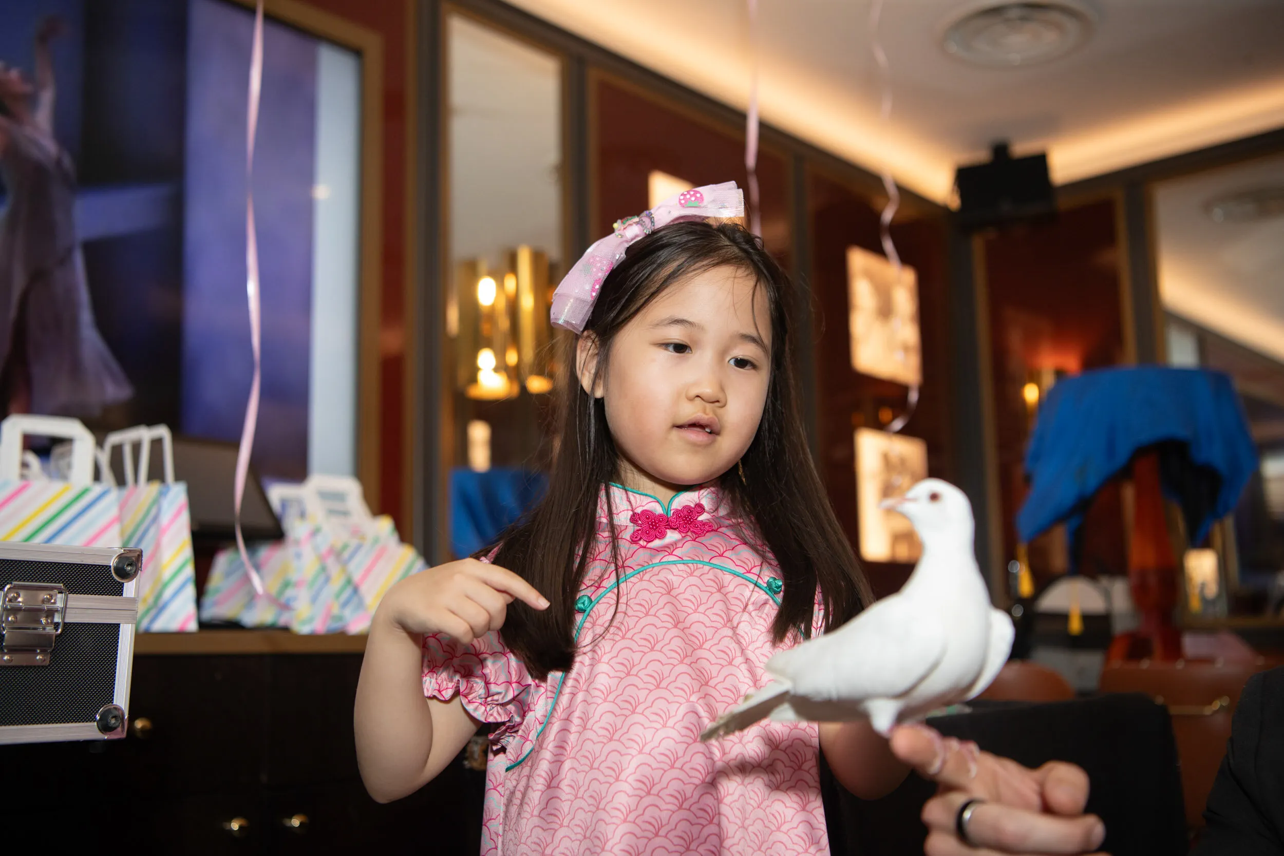A child watches the white dove perched beside her.