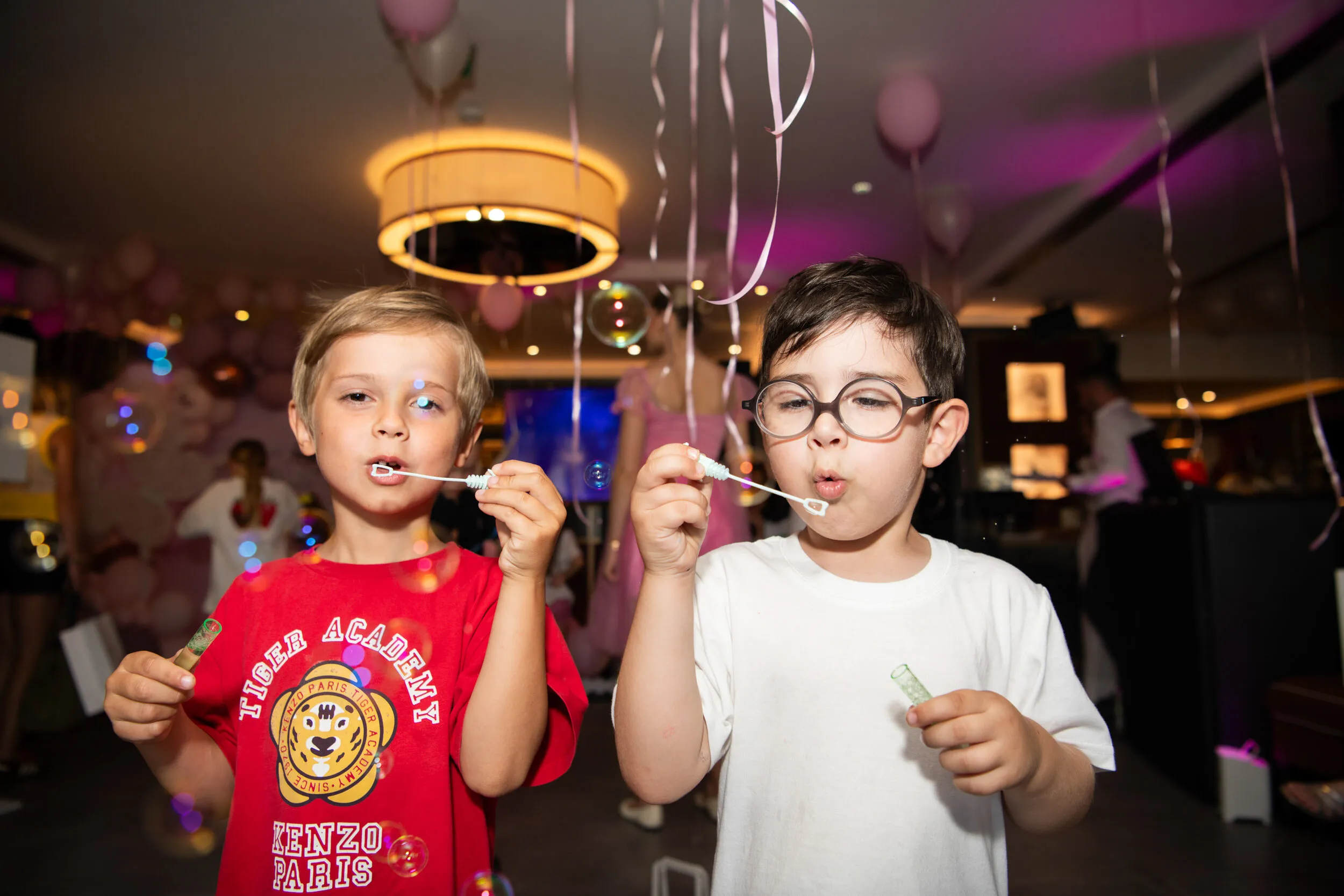 Two boys blowing soap bubbles.