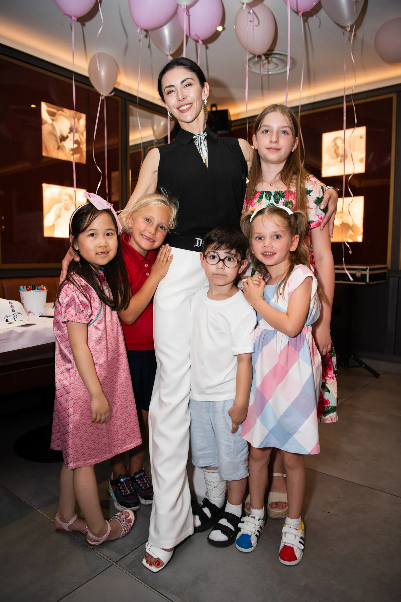 The founder surrounded by five children under the balloons.