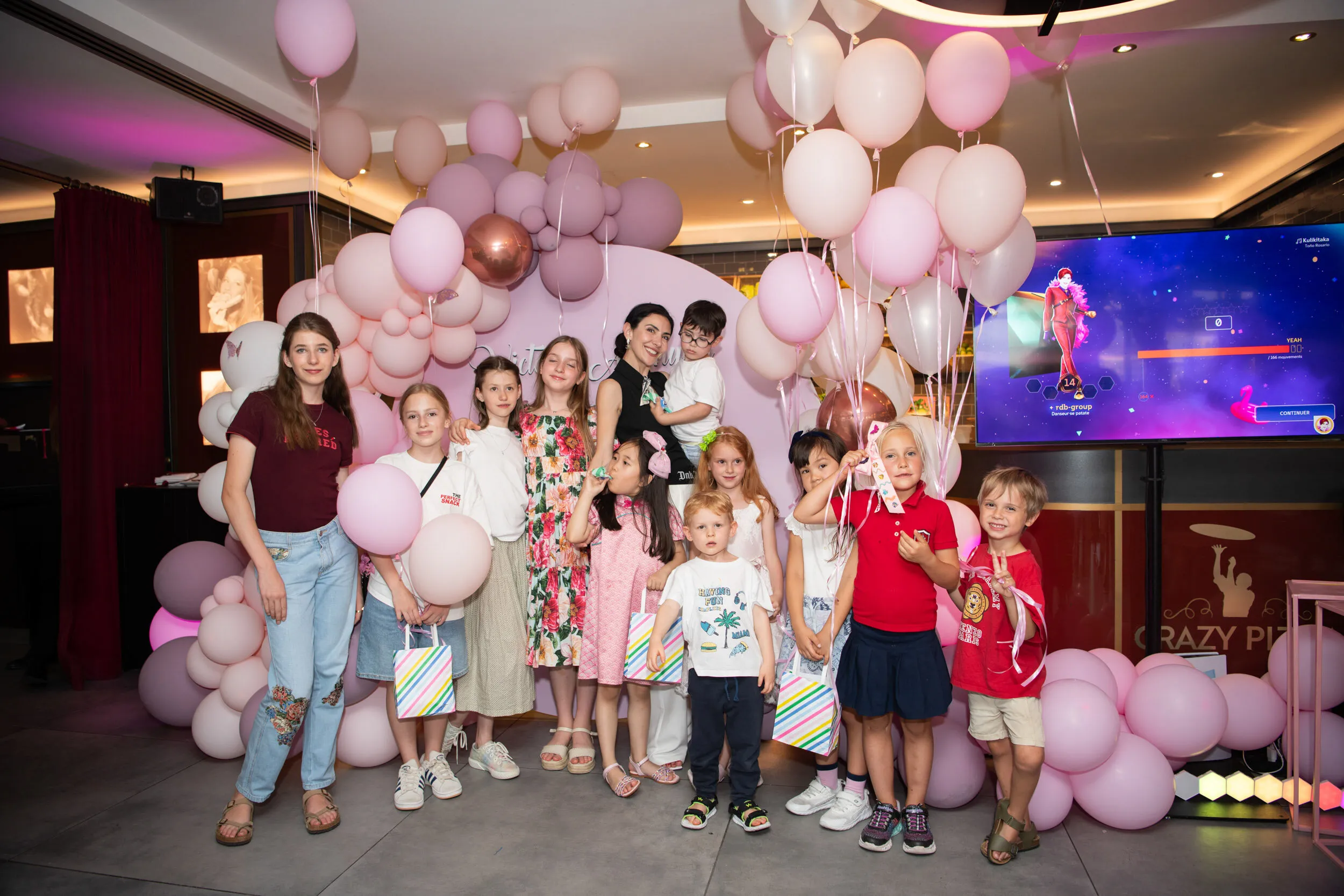 The group photograph of the party, children and the founder together under the balloon arch.
