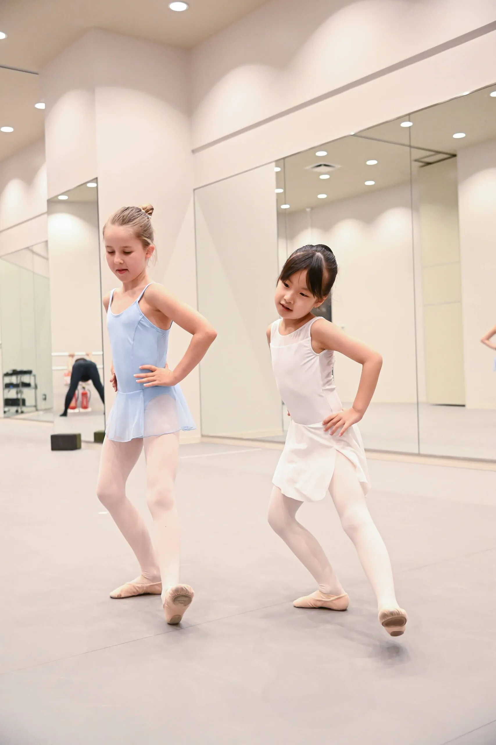 Two young students side by side in the centre of the studio, full figures.