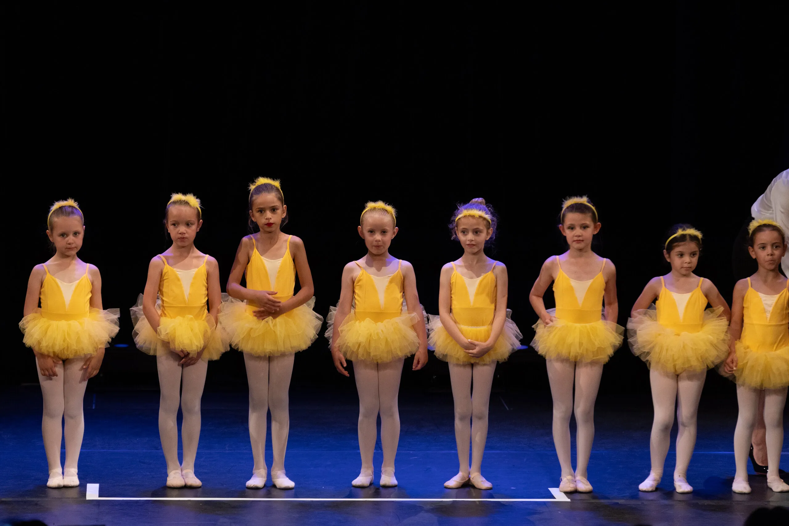 Une longue rangée de petites élèves en tutus jaunes, d'un bout à l'autre de la scène.