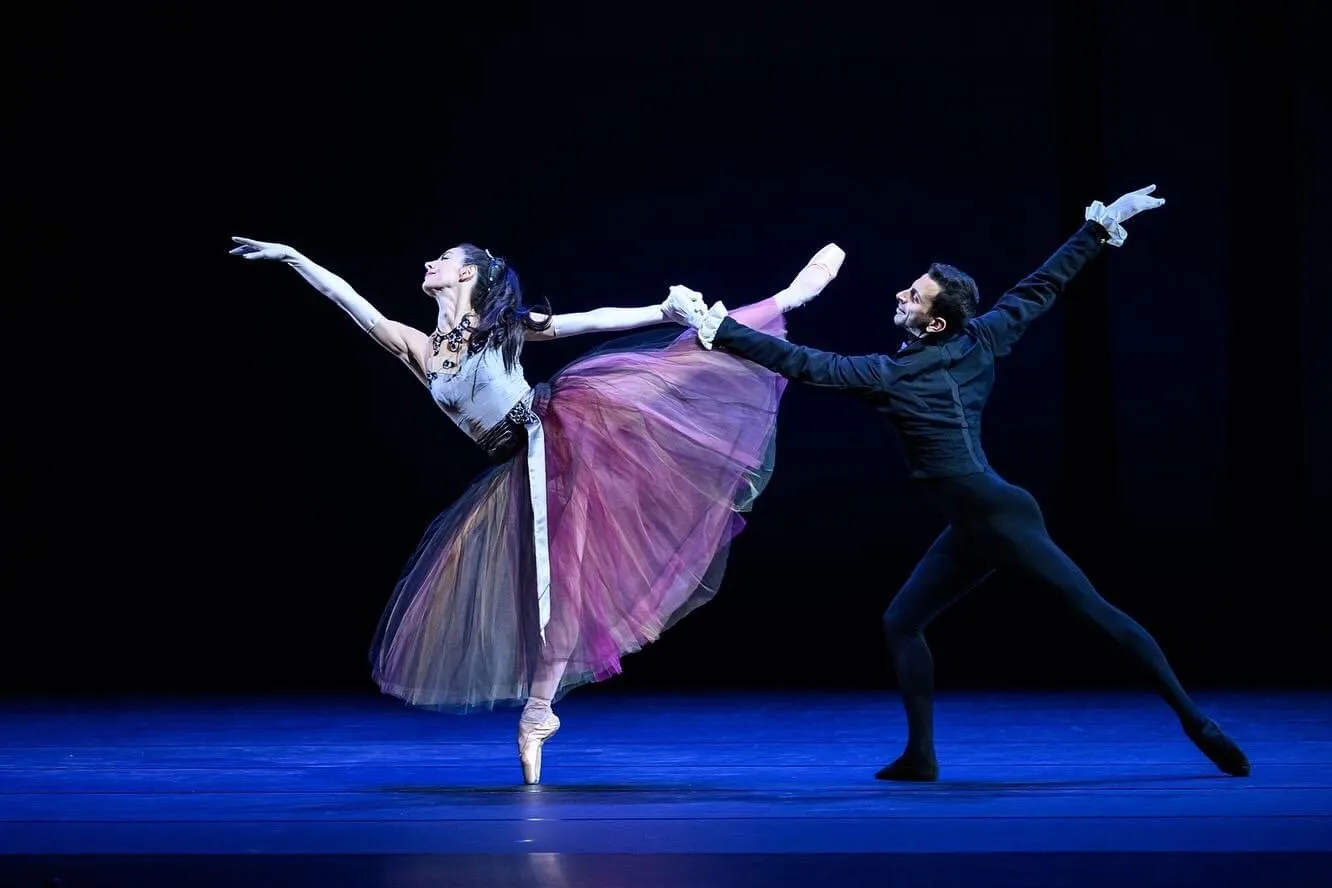 Le même pas de deux, Victoria en équilibre et son partenaire en fente, les bras tendus vers l'extérieur.