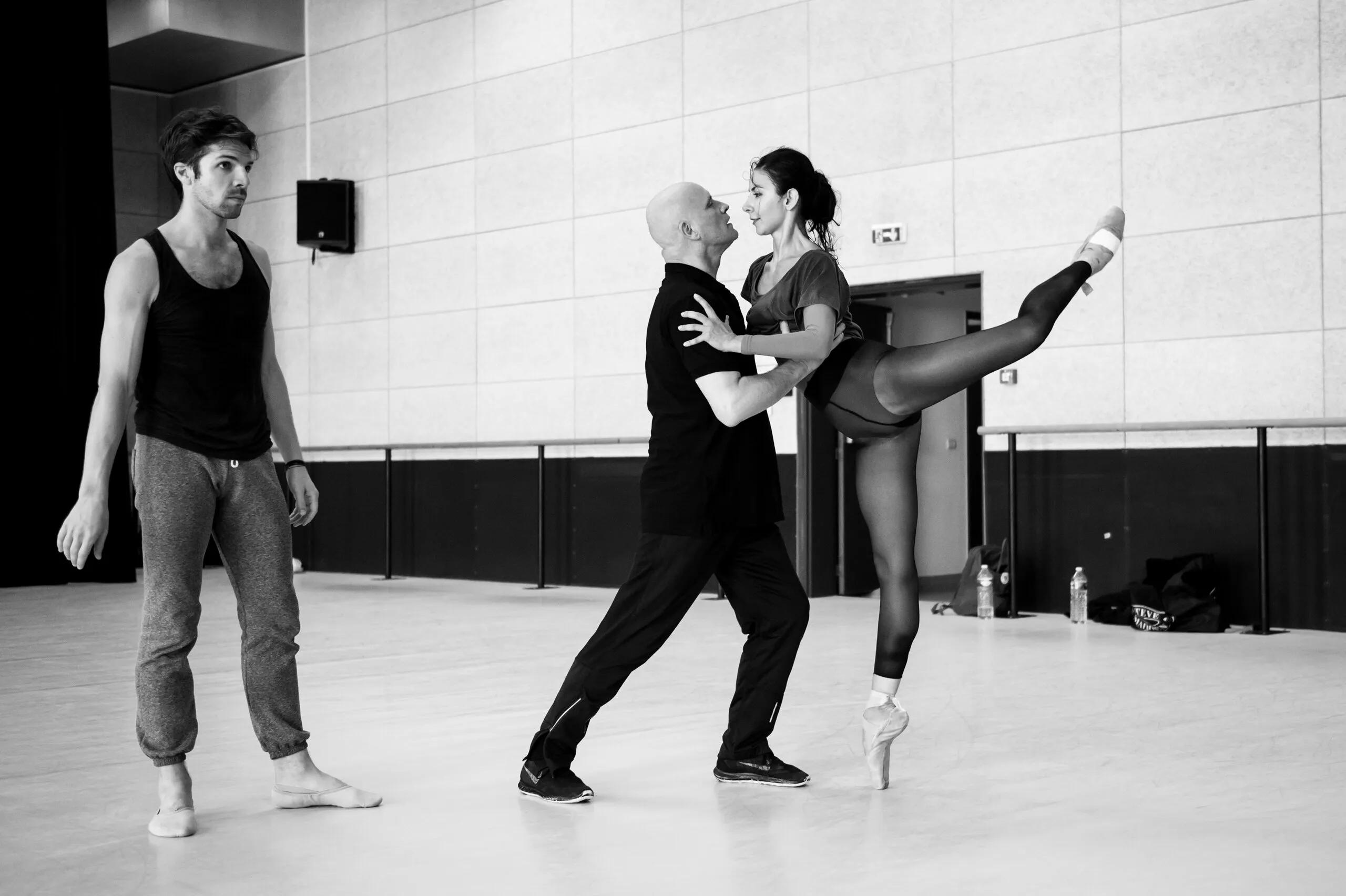 En studio, Jean-Christophe Maillot dirige une répétition, Victoria la jambe levée à ses côtés.